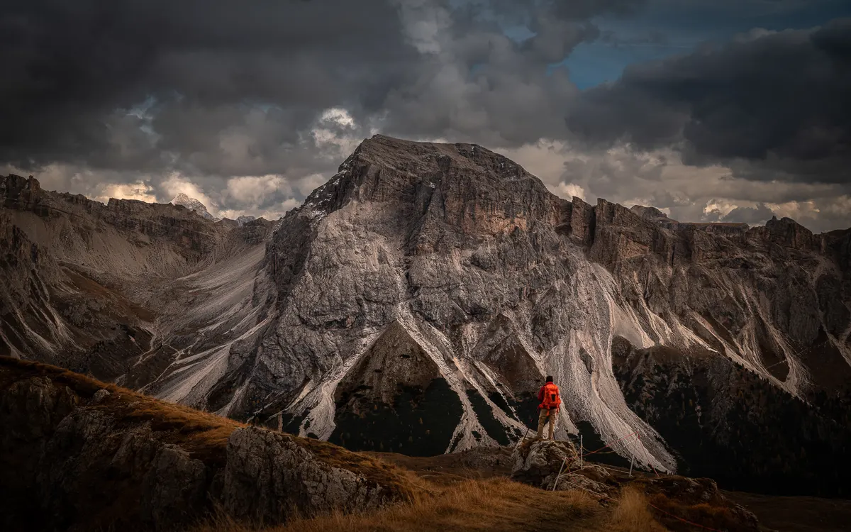 A traveller photographing a mountain range at dawn
